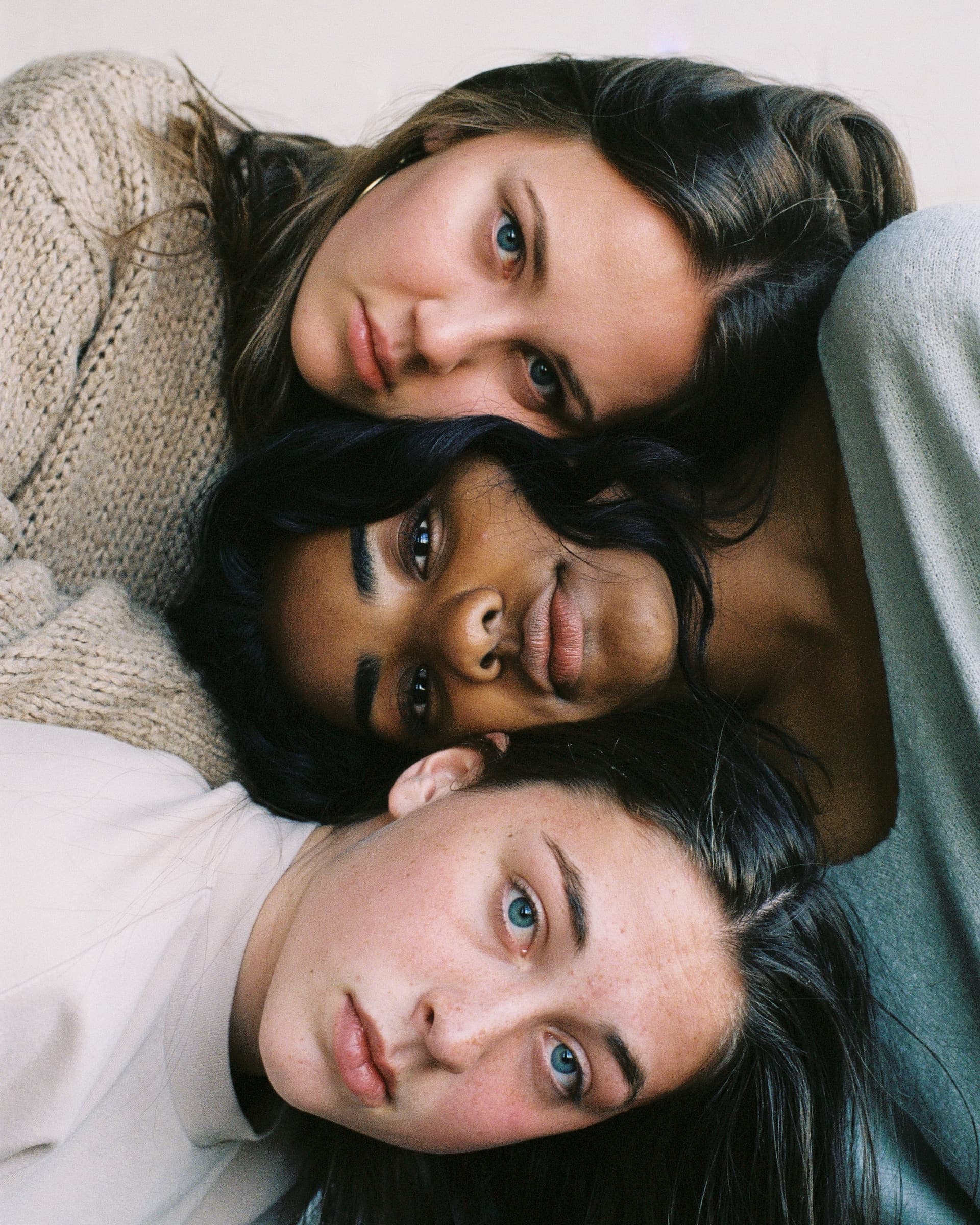 Portraits of 3 beautiful young women of diversity with their faces side by side