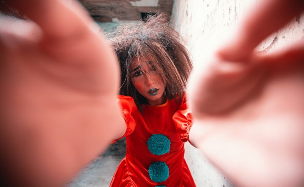 woman dressed as a clown is holding her hand in front of her