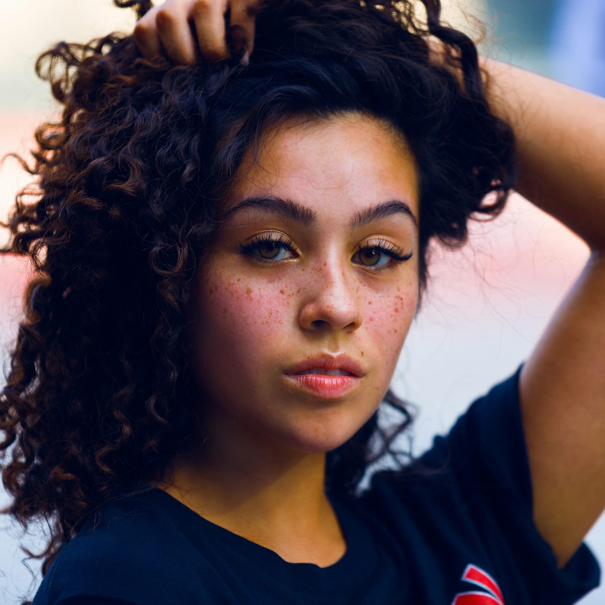 portrait of a beautiful black woman brushing her hair with one hand